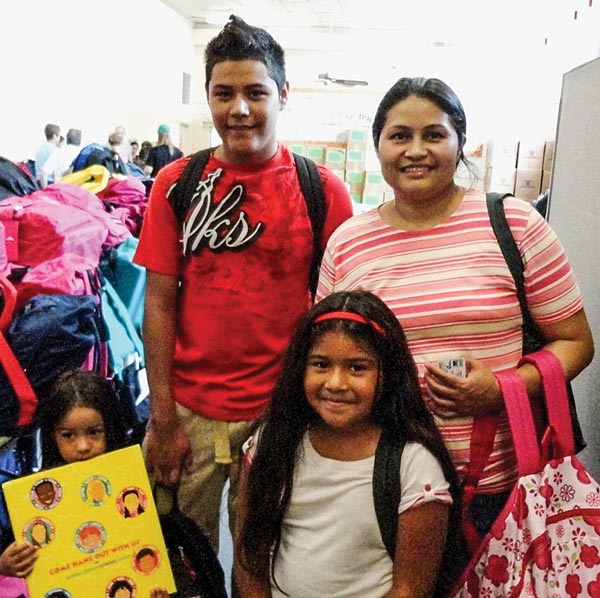 Family getting a backpack during the United Community back to school event.