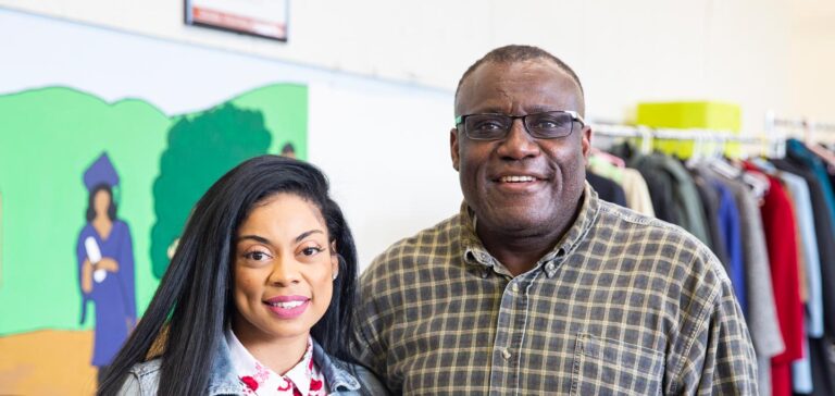 A staff member and client smiling for a picture at the main office