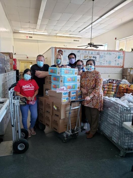 United community staff and volunteers standing next to food donation