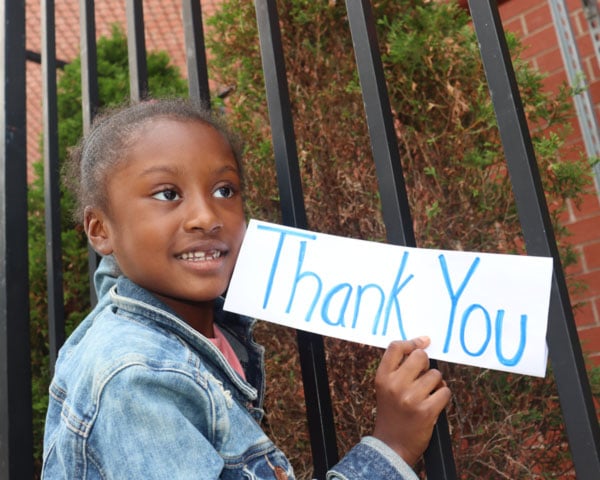 Young student holding a thank you sign