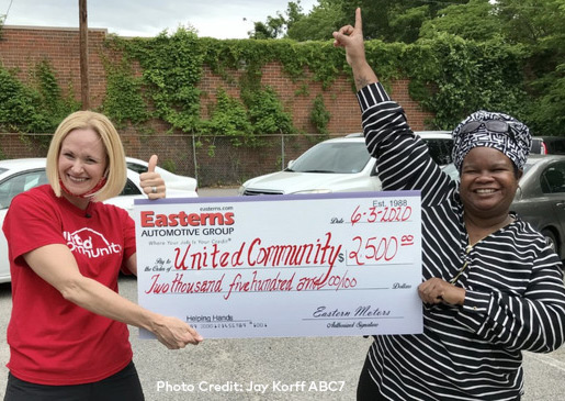 Alison DeCourcey and Yolonda Thompson holding a donation from Easterns Automotive Group