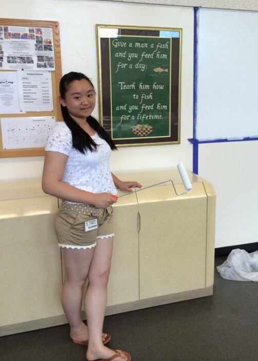 Young lady standing in front of size after making donations