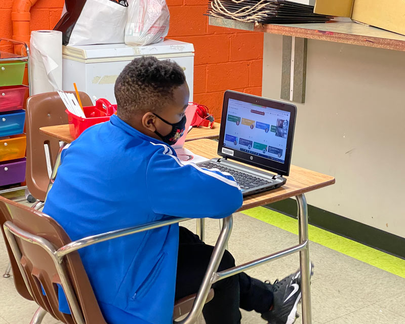 Student being tutored online at Creekside Village Community Center