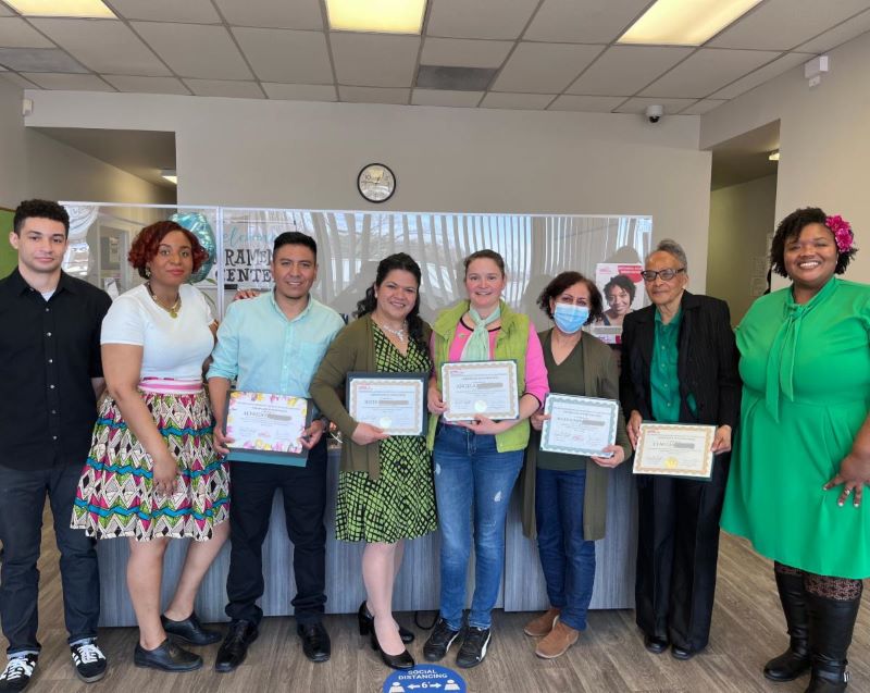 Five of the THRIVE graduates with three of the instructors pose and smile with their certificates