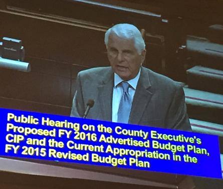 Jim Seeley, is shown on the tv testifying at a Fairfax County Budget hearing on behalf of United Community