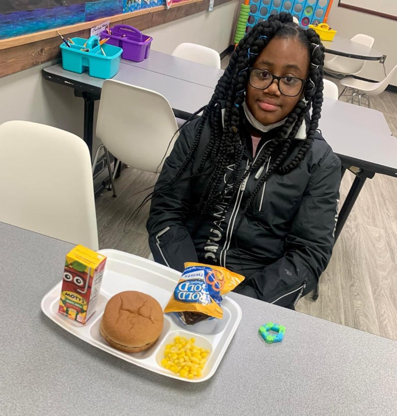 A young girl at Sacramento Neighborhood Center enjoys a hot meal after school