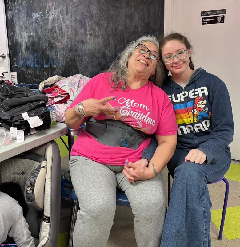 Two volunteers smiling as they pose for a photo at the thrift day