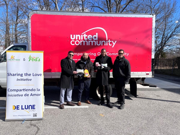 Supervisor Lusk, and De Lune’s President, Gaddafi Ismail, and Dave Anderson of Untied Community pose in front of one of United Community's trucks