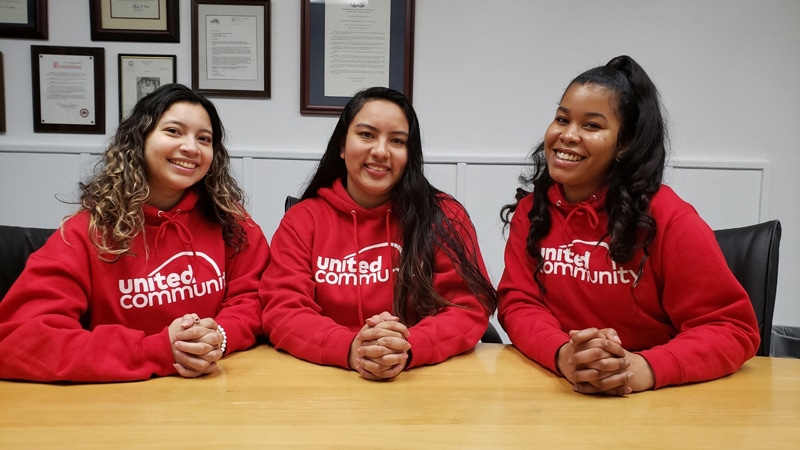 Three smiling young woman, all coaches for the Family Achievement Program