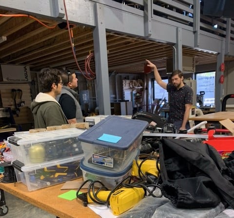 Two men listen to another instructor as they start their new job with Building Momentum