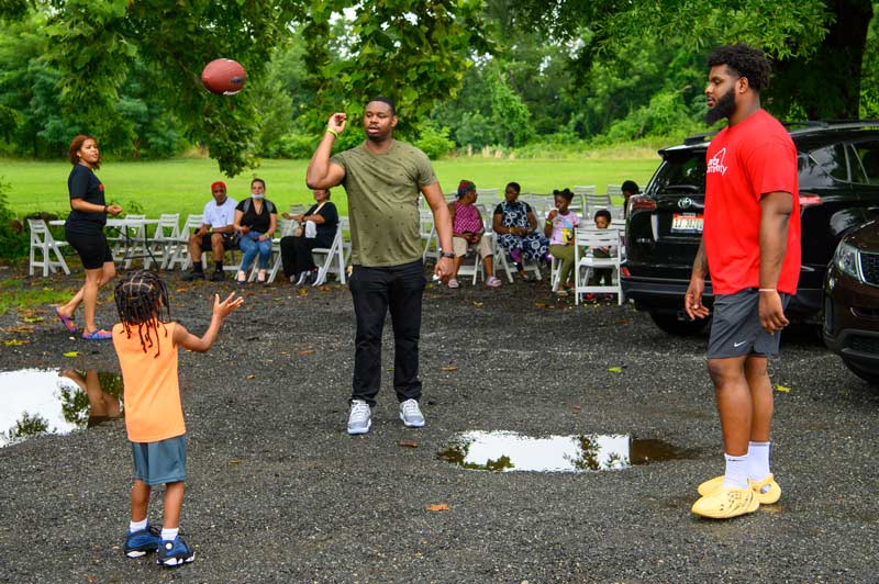 Rasheed throwing a football around with friends at our Family Fun Day