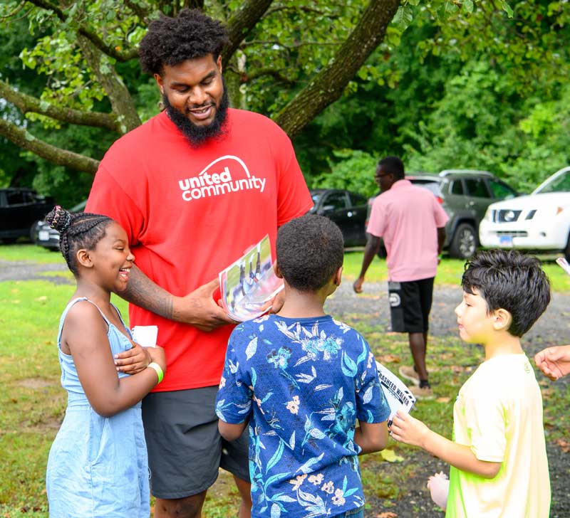 Rasheed with three kids, signing autographs for them